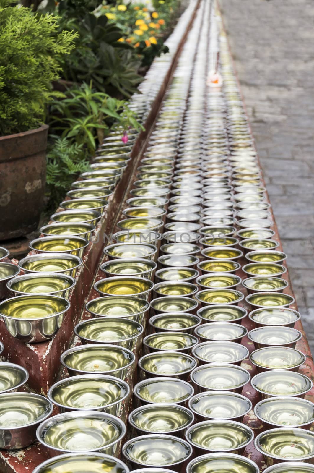 many small bowls with water around a temple in nepal