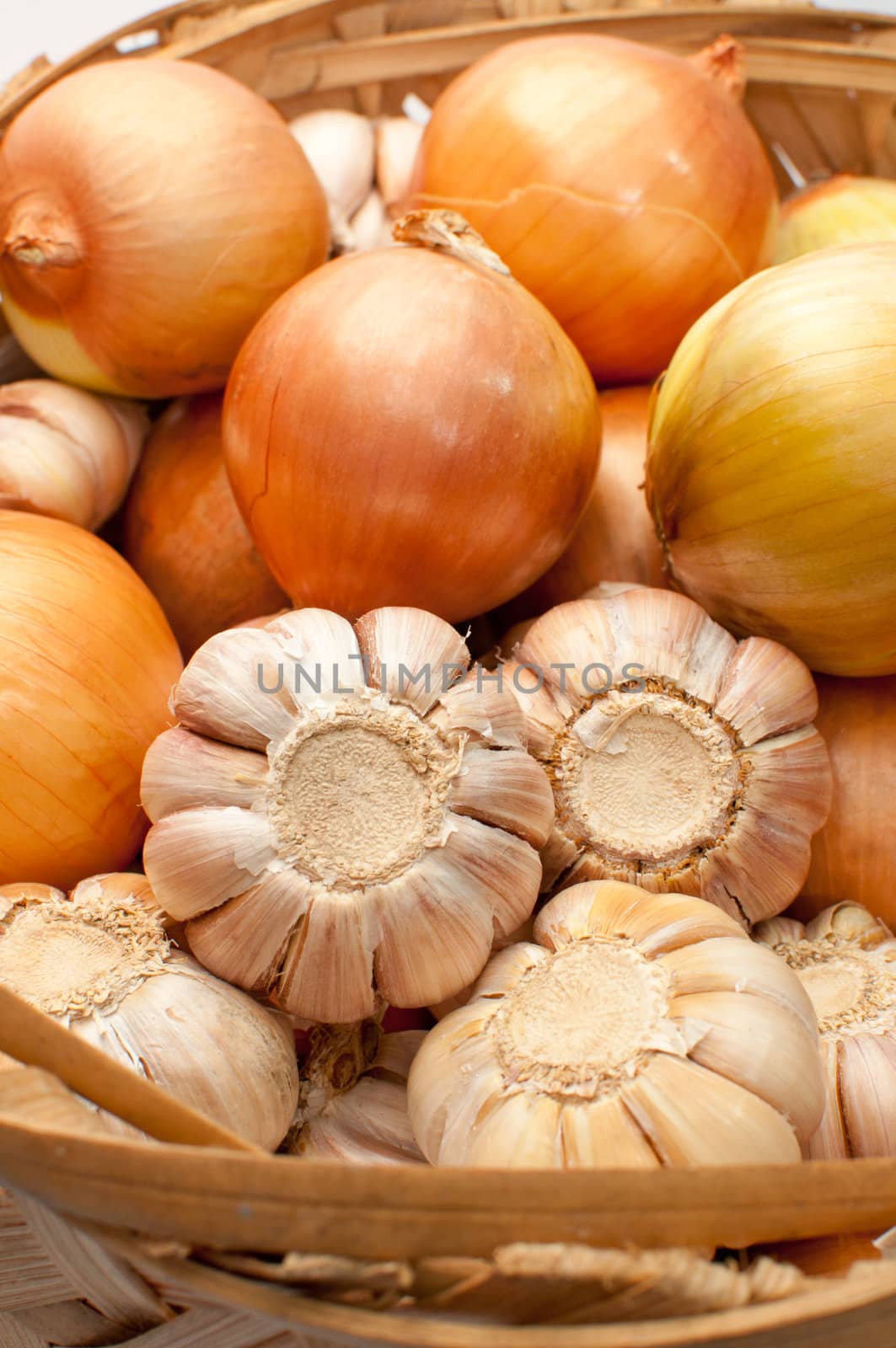 Garlic and onion bulbs in bamboo basket