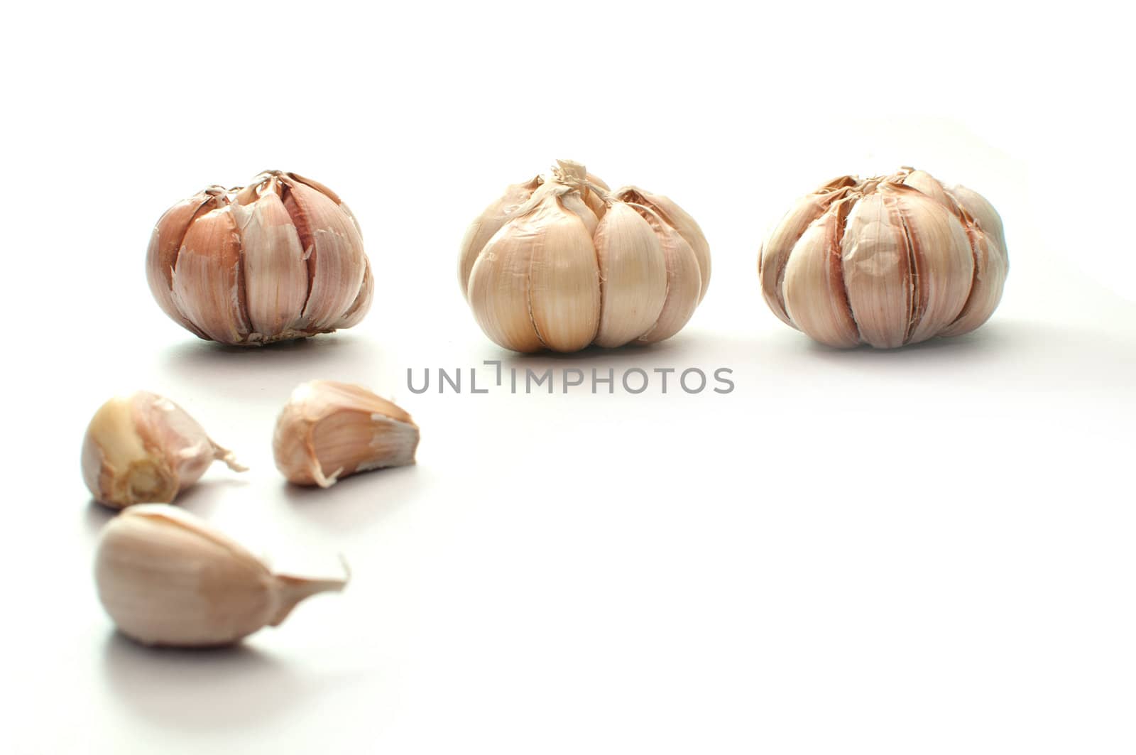 Garlic bulbs in three positions, isolated on white