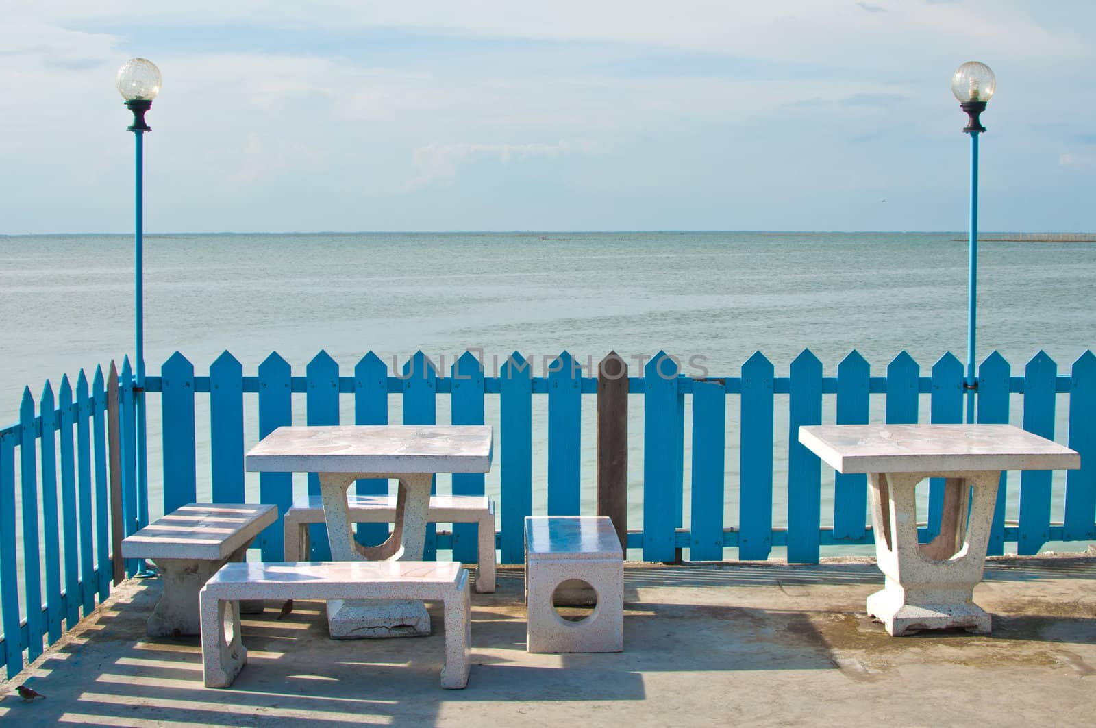 Set of marble benches and lamp by the sea