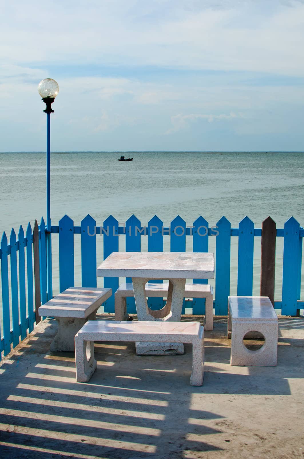 Set of marble benches and lamp by the sea