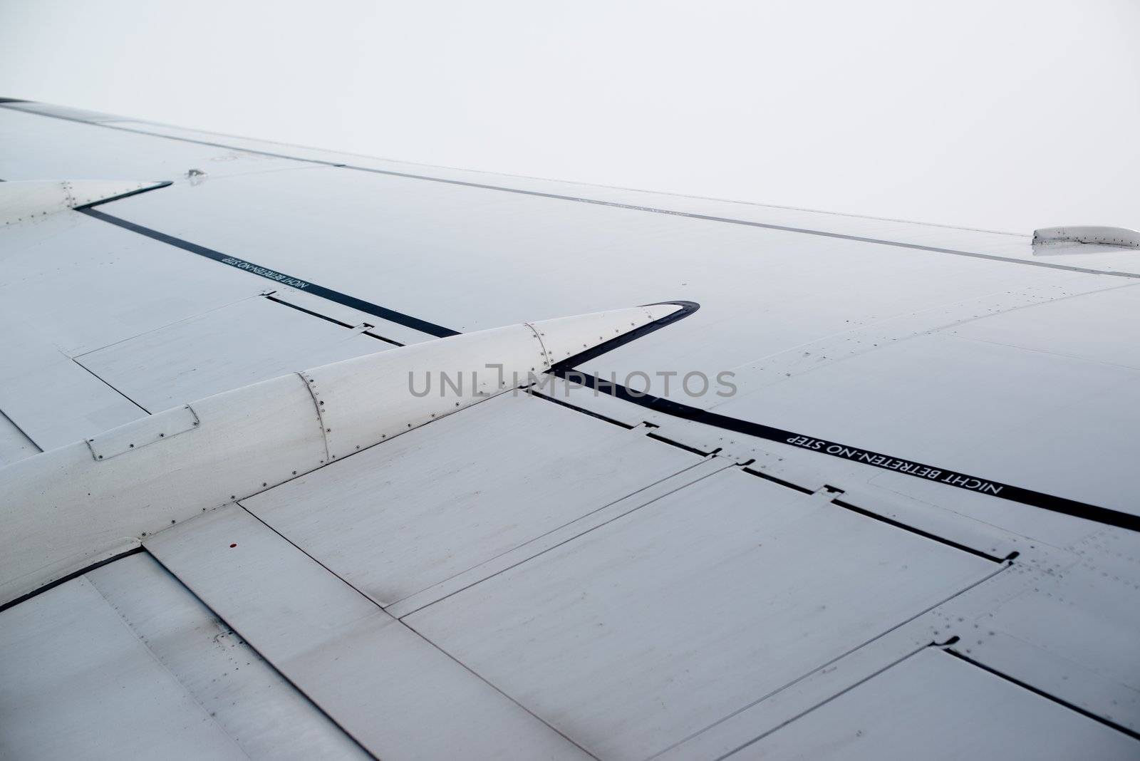 airplane wing, sky and clouds as seen through the cabin window