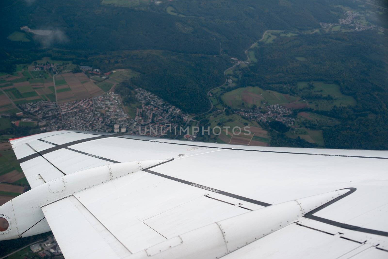 airplane wing and landscape as seen through the cabin window