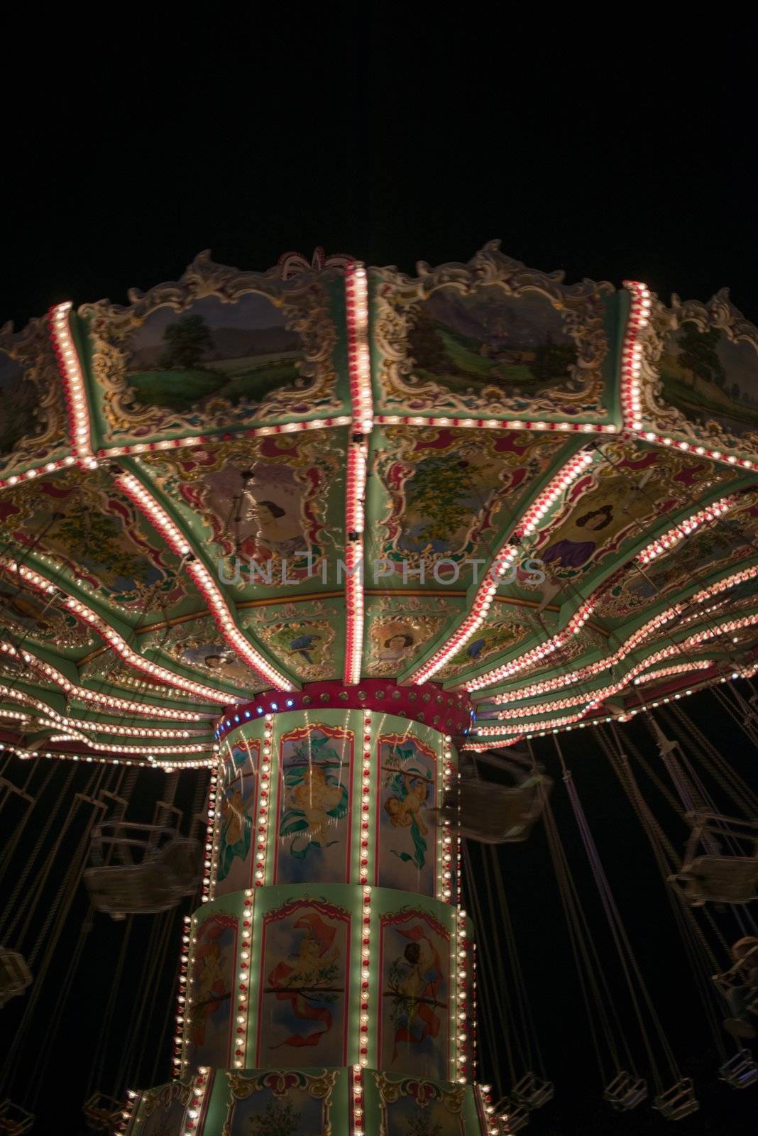 Beautiful old chain carousel with people at night