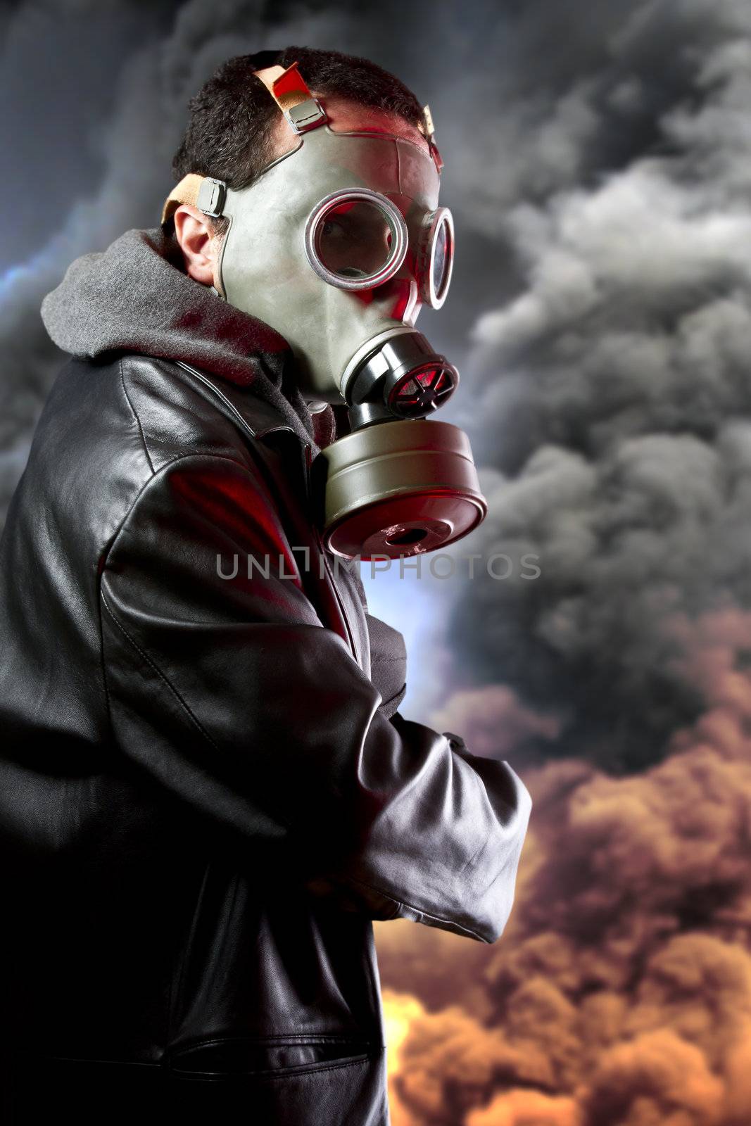 Armed man with gas mask over explosion background