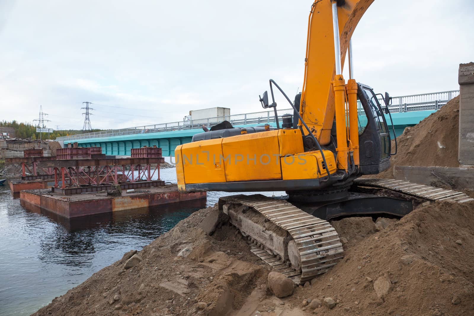 Excavator builds a bridge. Russia. North. Taiga.