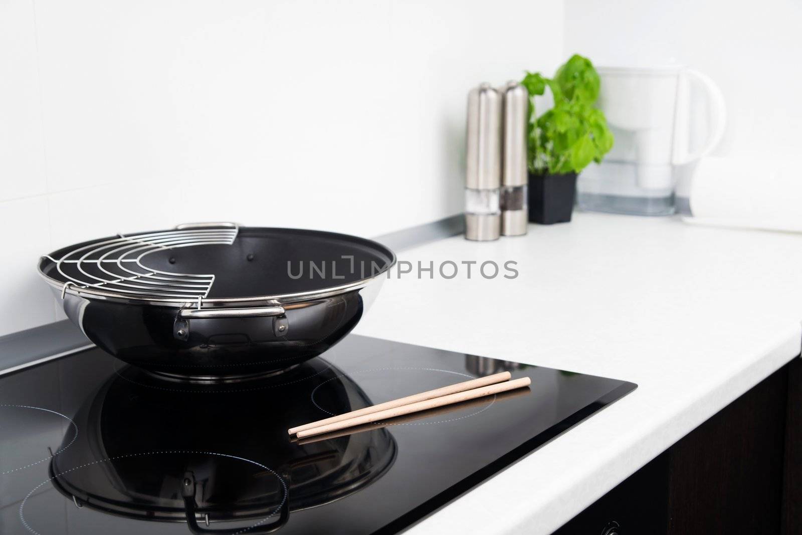 Frying pan and sticks in modern kitchen with induction stove
