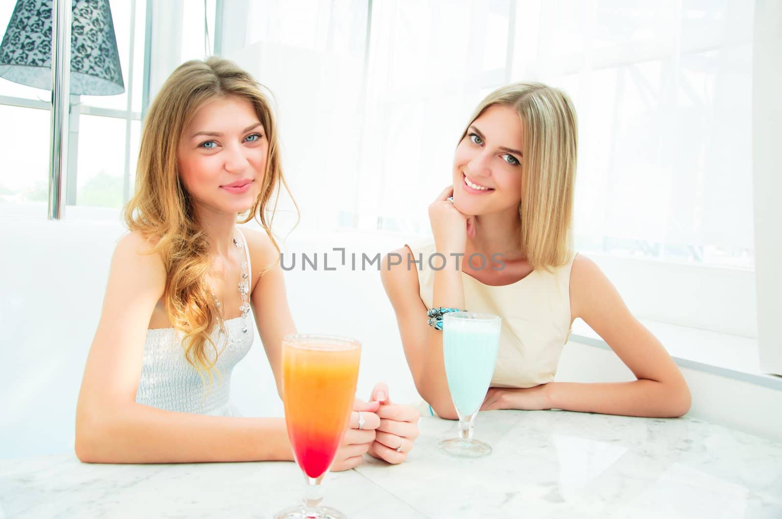 two beautiful girls, have a nice time, chatting in a cafe