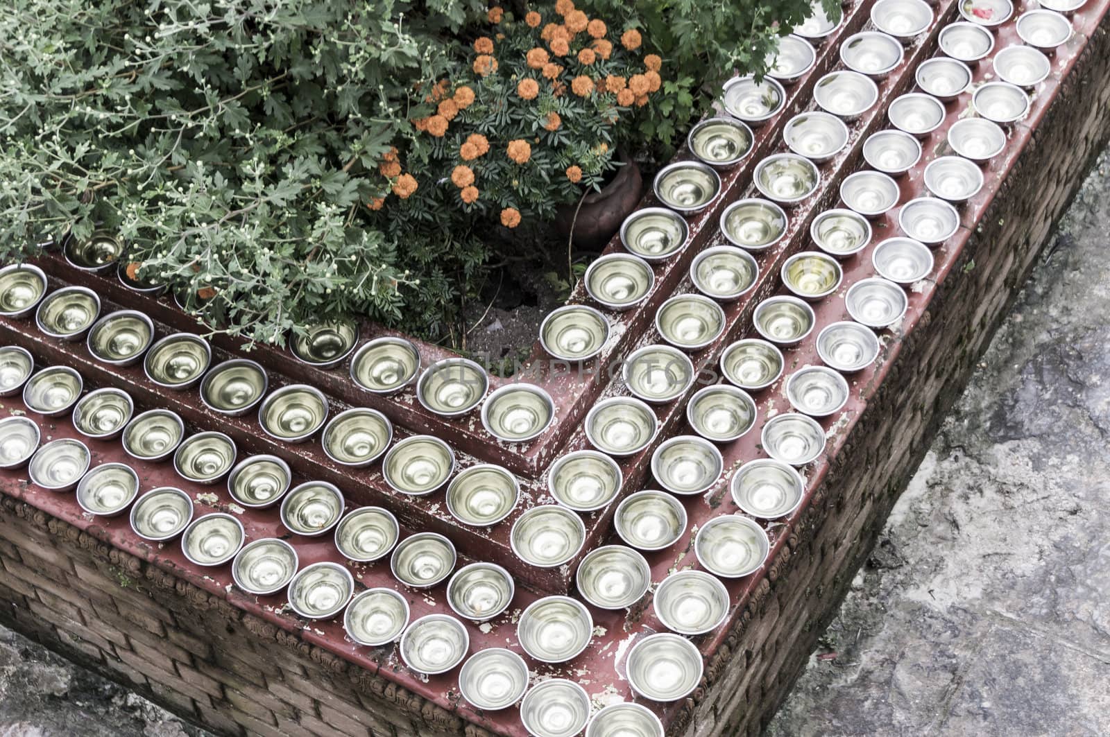 many small bowls with water around a temple in nepal