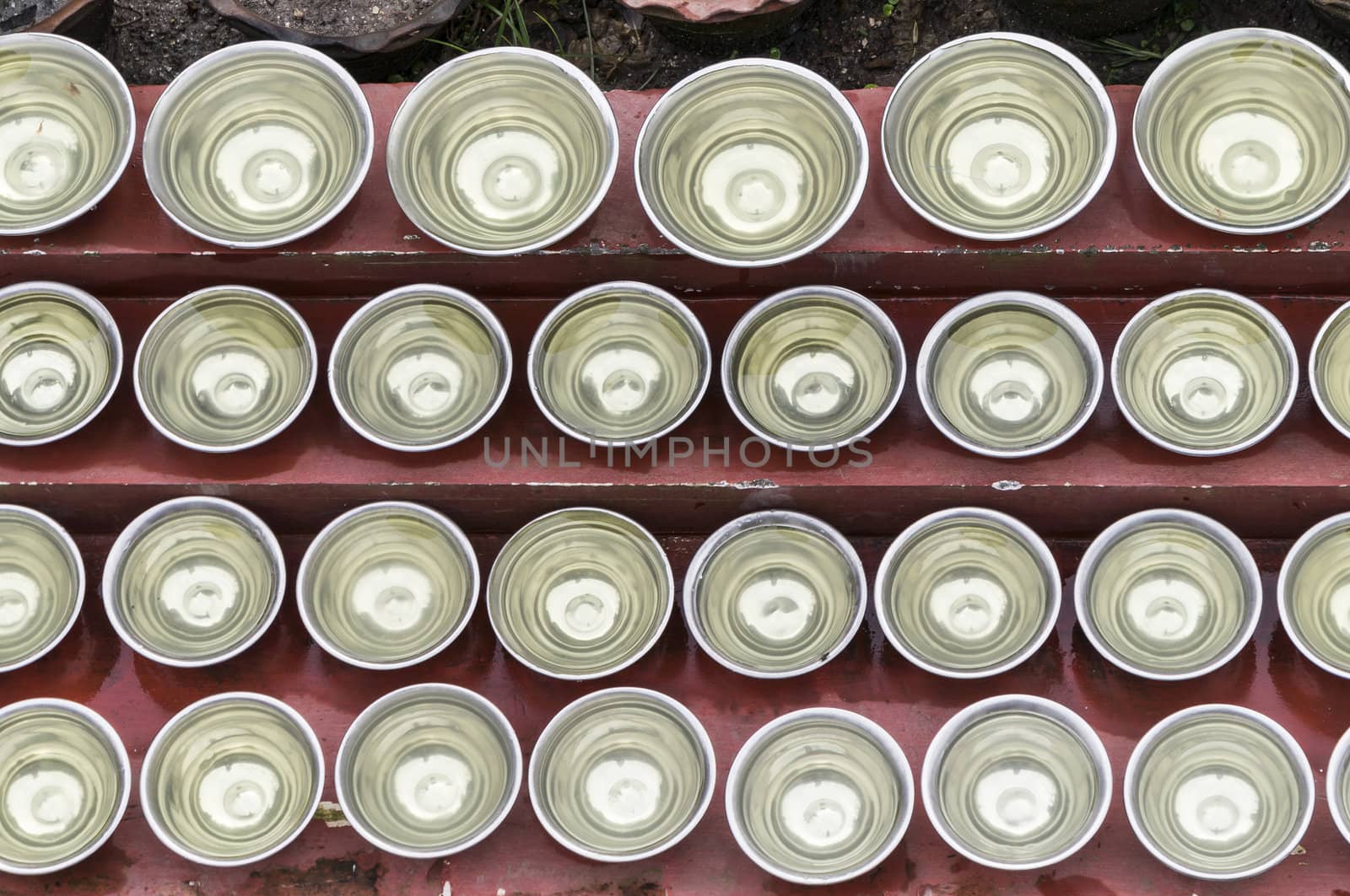 many small bowls with water around a temple in nepal