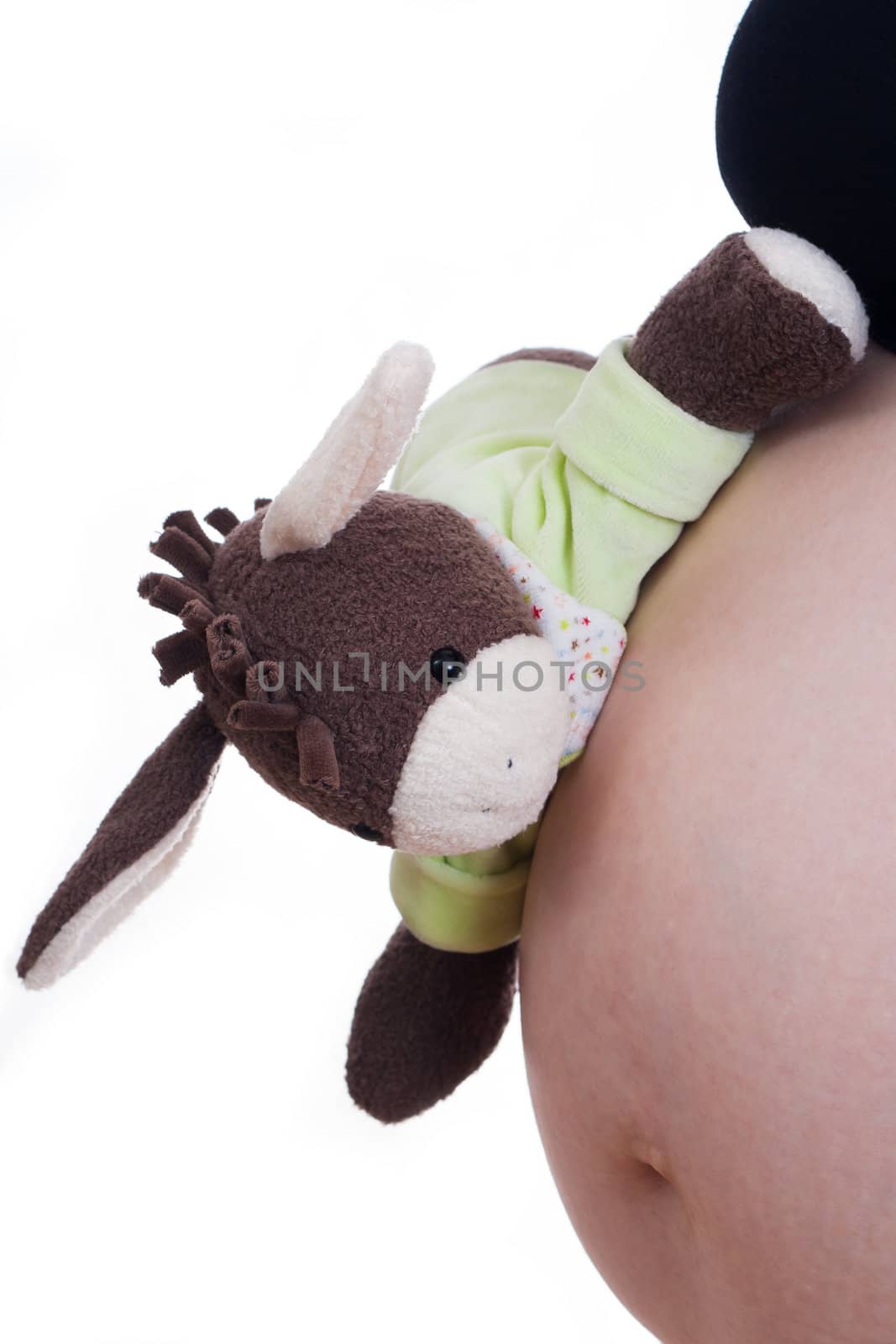 Pregnant girl showing her belly and holding a toy