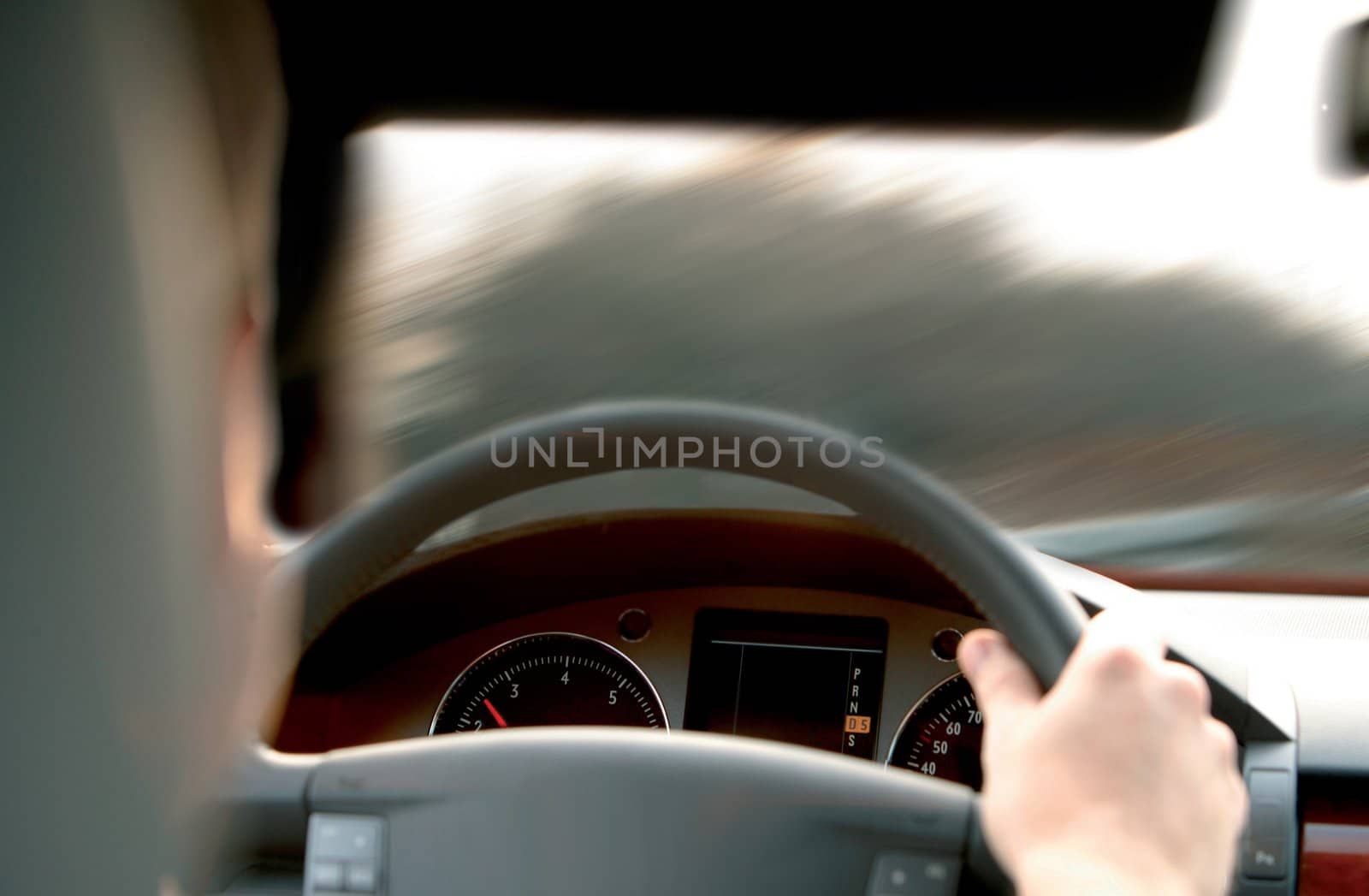 driver holds wheel in car and goes on road