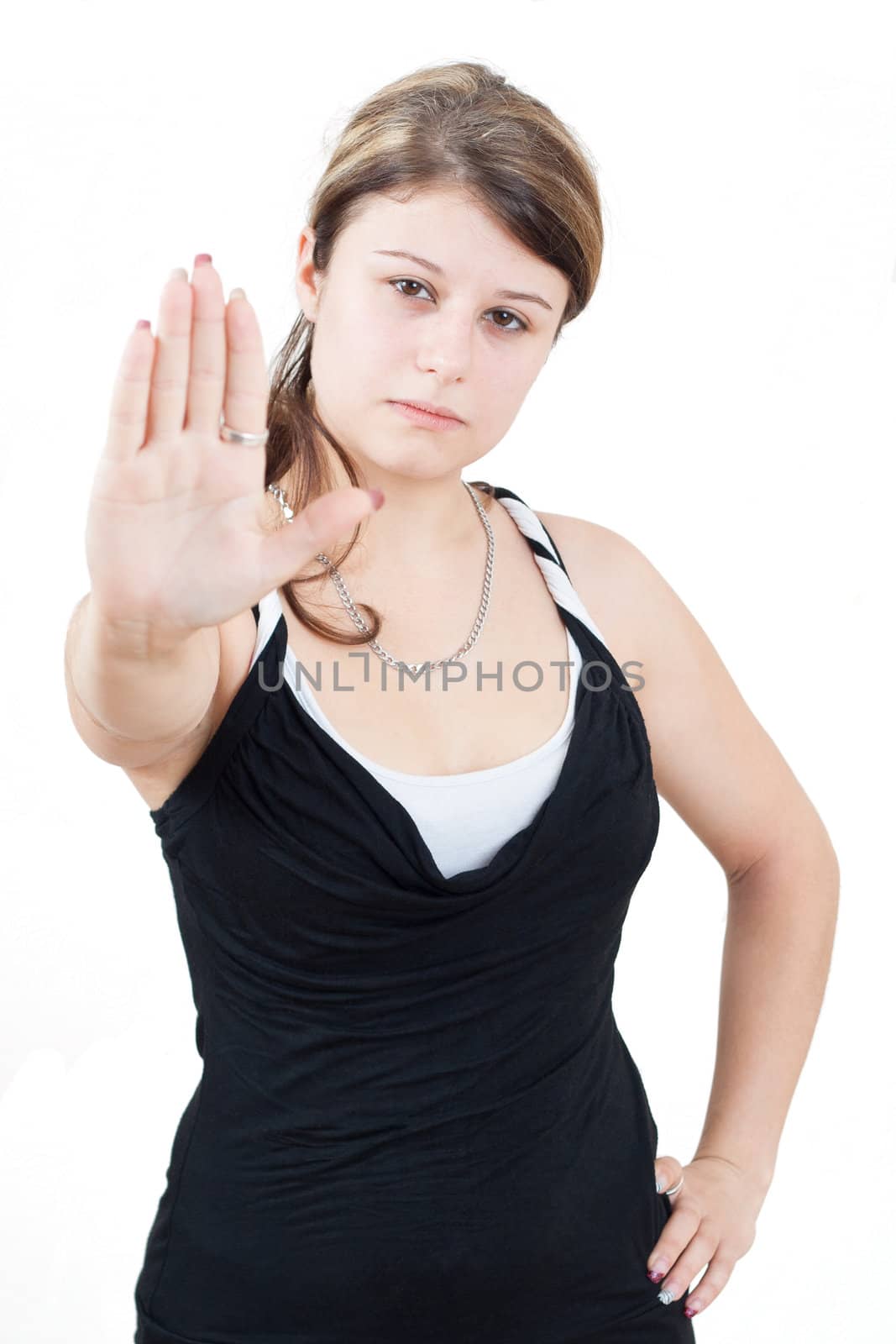 young brunette girl with brown eyes is showing the stop gesture on white background