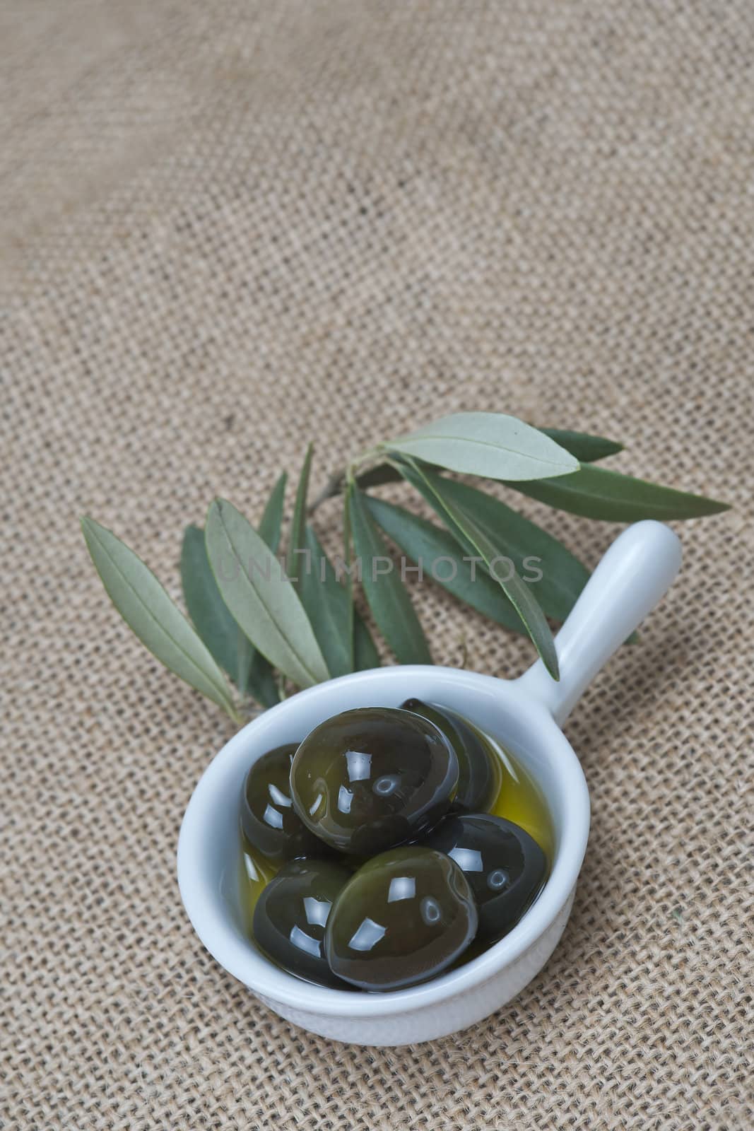 Saucer with olives on a burlap by angelsimon