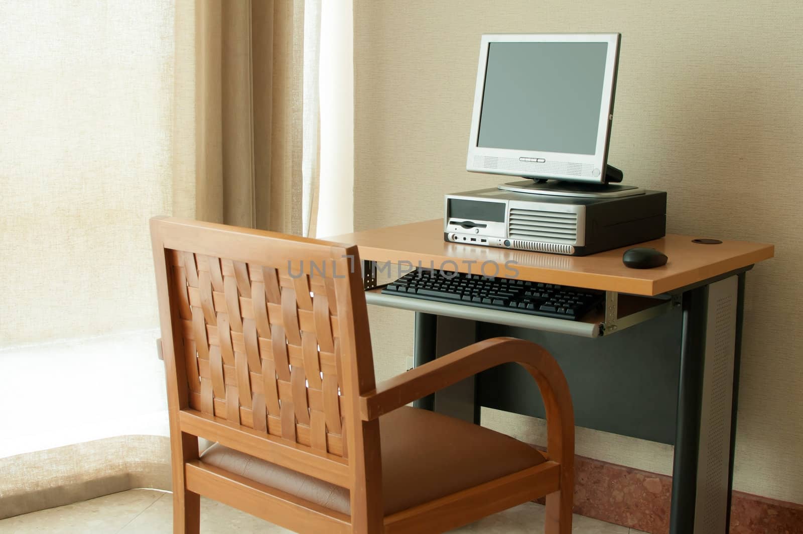 Workstation computer on table and wooden chair by TanawatPontchour