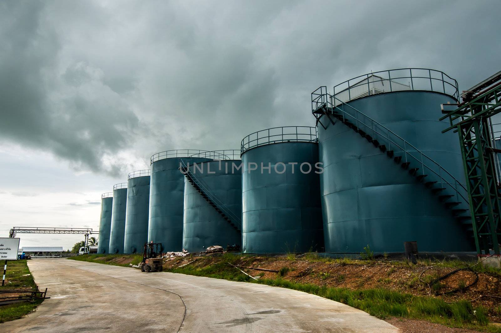  Vertical picture of  storage tanks and ladder on cloudy background