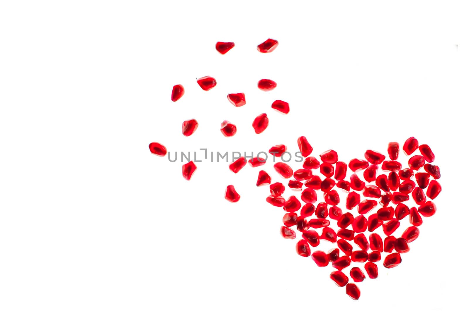 heart shape made by pomegranate seeds isolated on white by TanawatPontchour