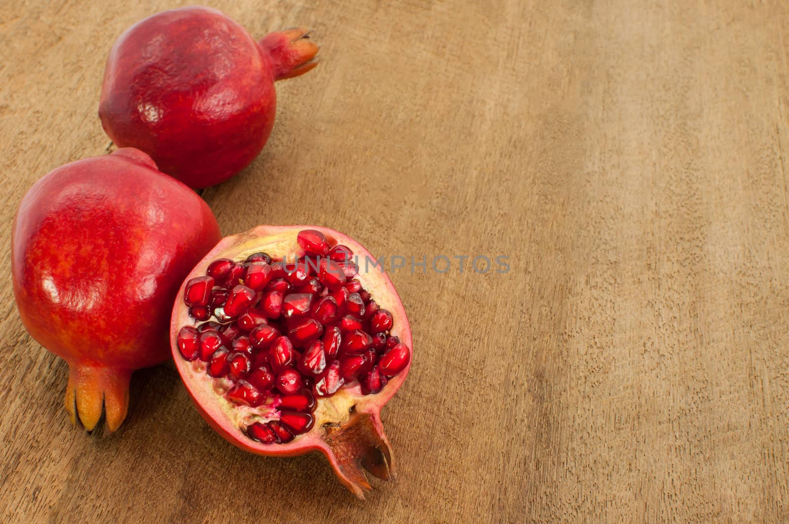 group of pomegranate isolated on wood background by TanawatPontchour