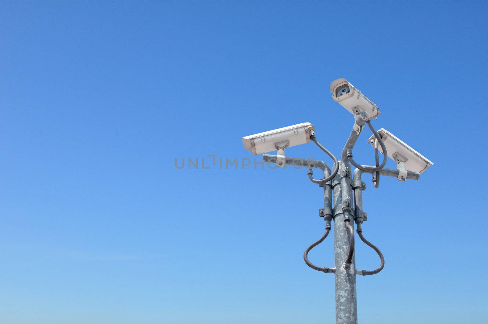 Three outdoor security cameras with housing on the pole cover multiple angles.clipping path included