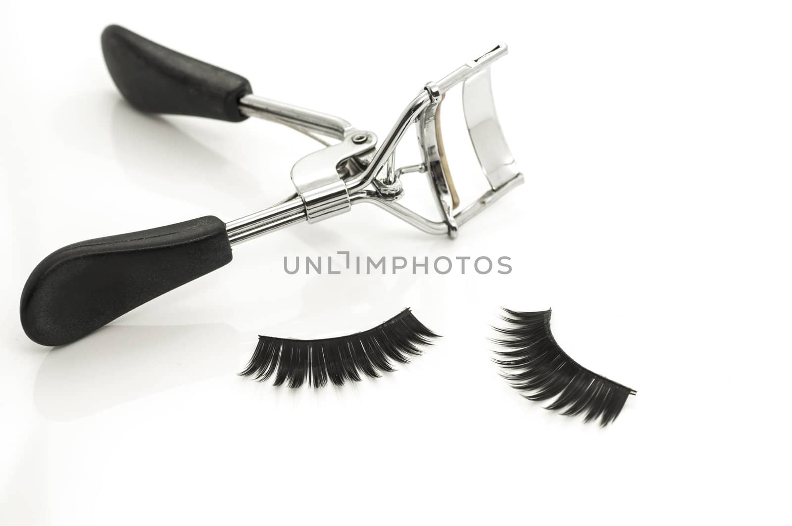 Macro of eyelash curler and false eyelashes isolated on white