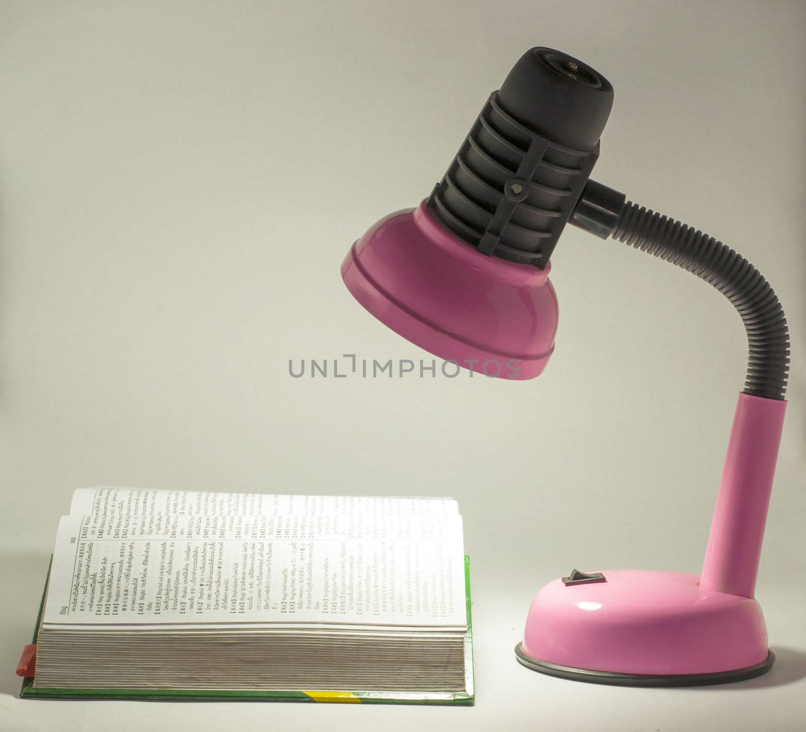 Electric pink table lamp and opened book