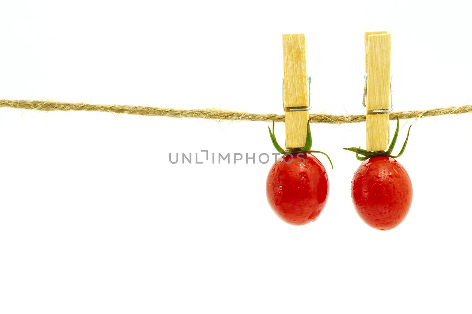 Two tomato hangin on clothespin,concept