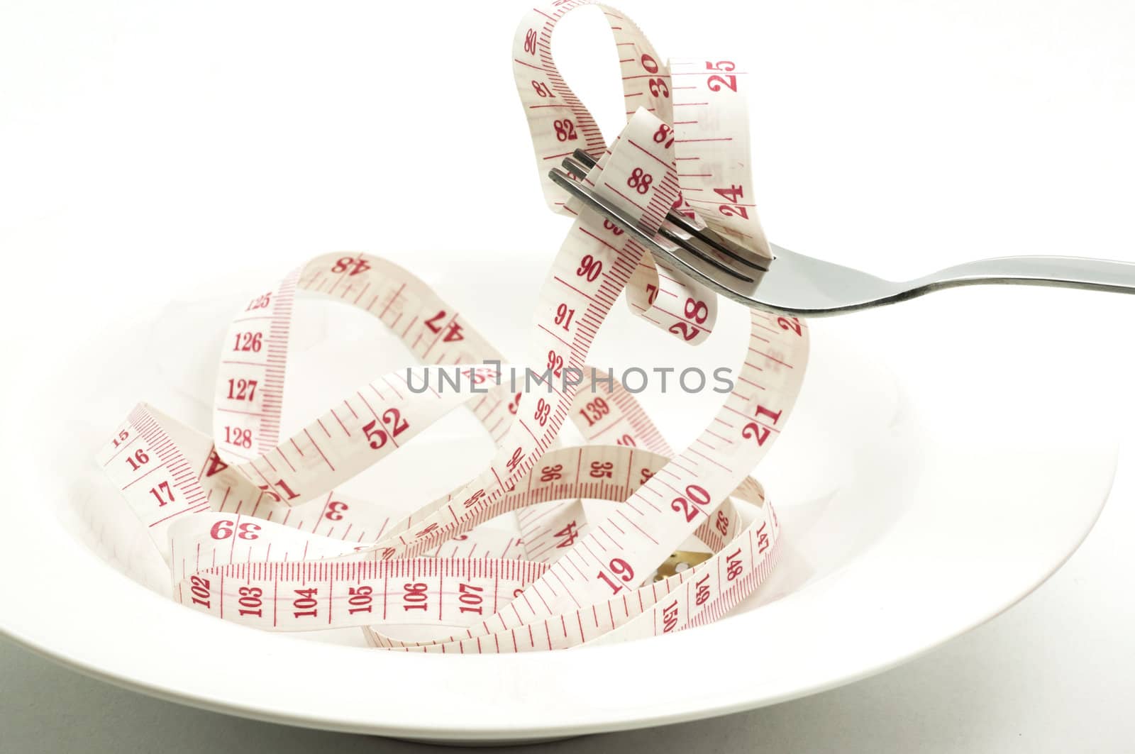 fork and measuring tape in white plate by TanawatPontchour