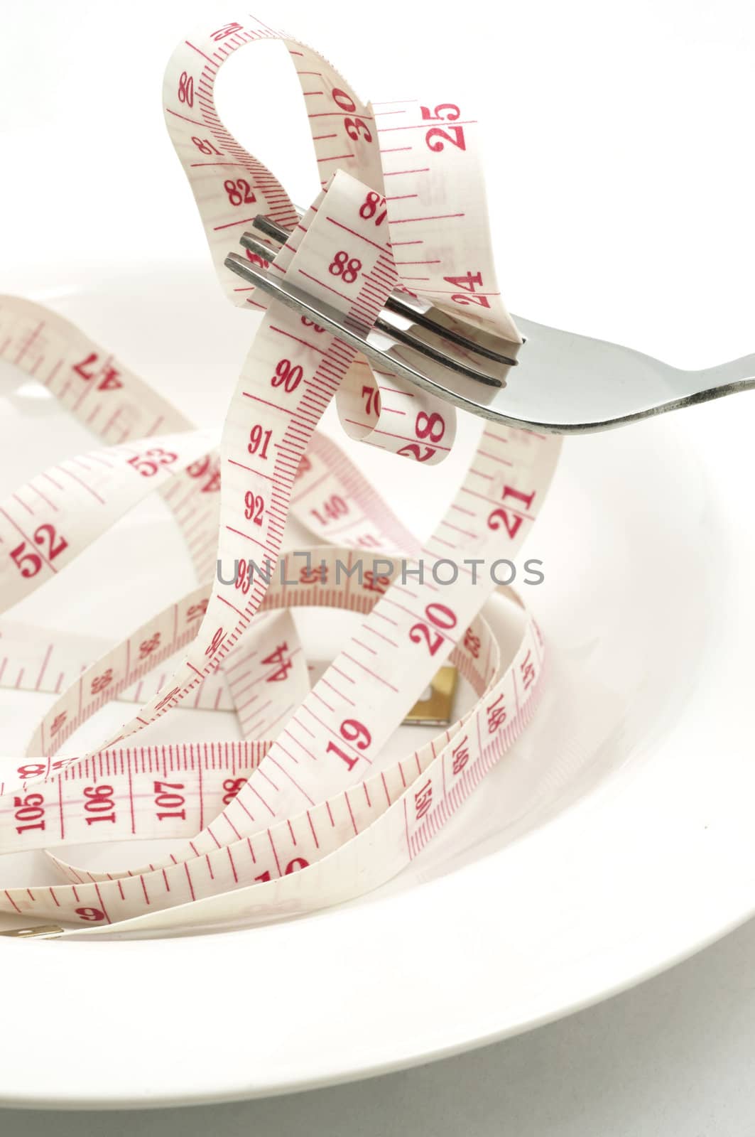 fork and measuring tape in white plate by TanawatPontchour