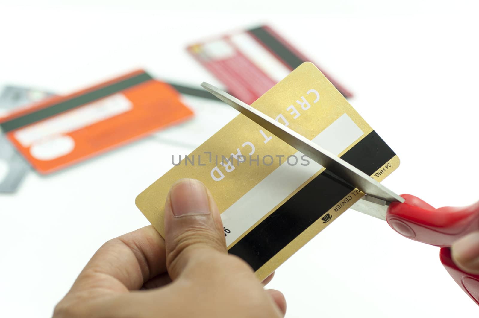 cutting up credit card with scissors by TanawatPontchour