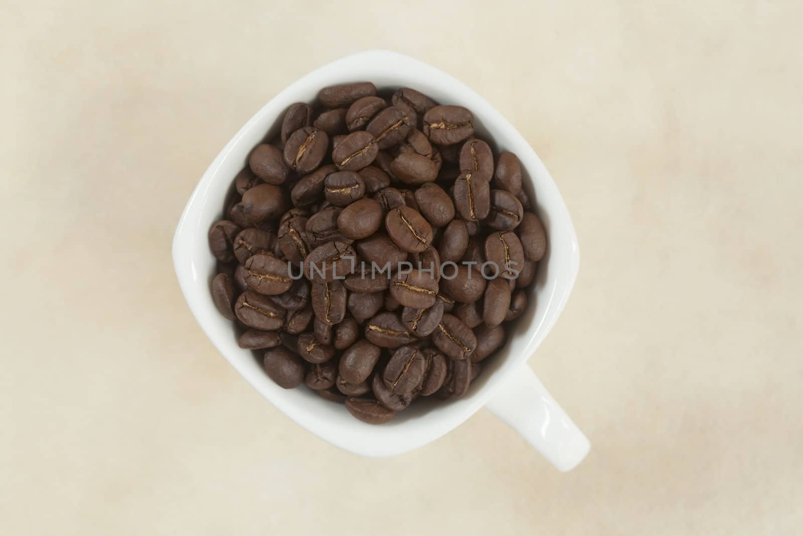 Coffee beans in a cup on paper background