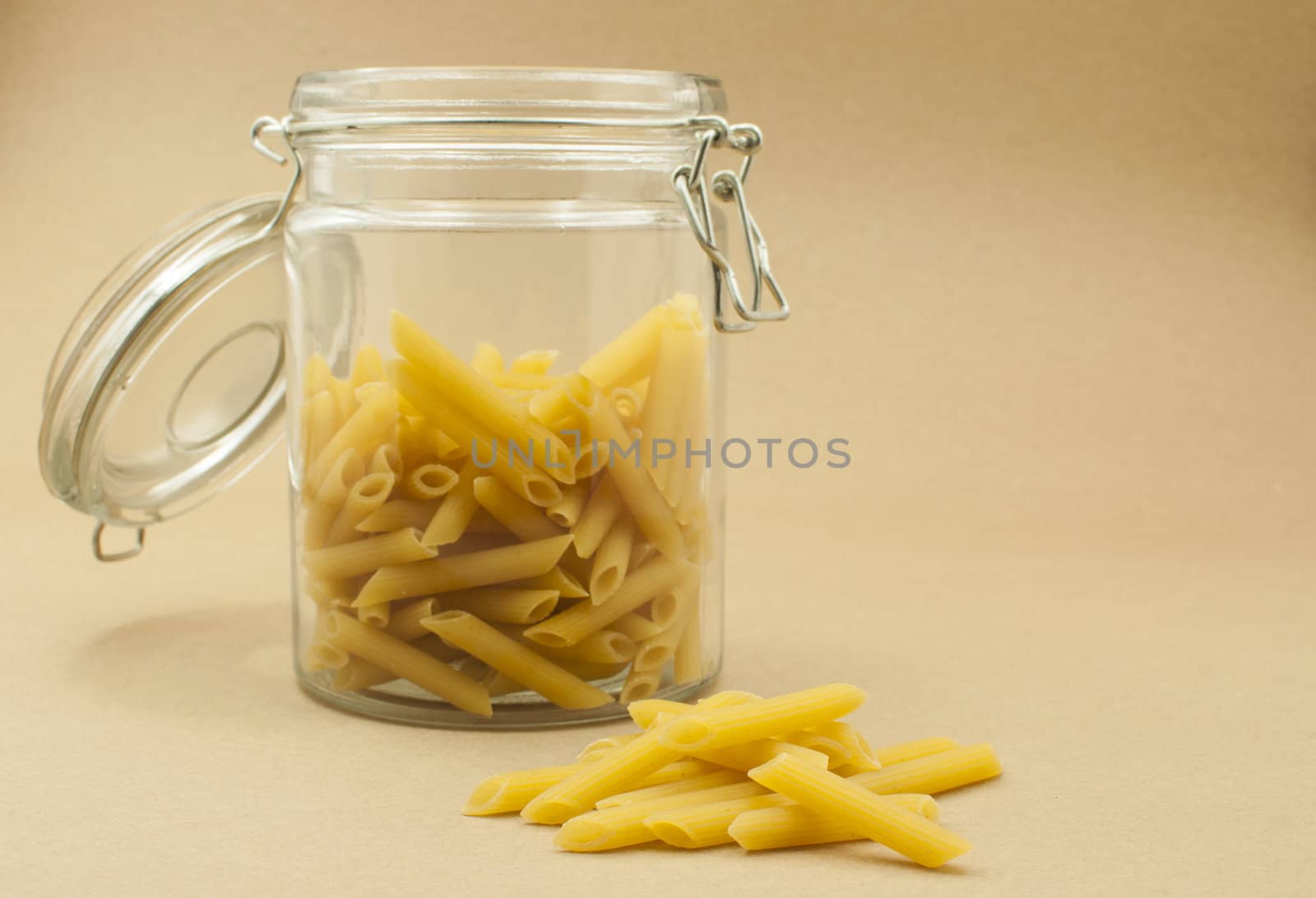 Pasta in glass bottle on wooden color  background