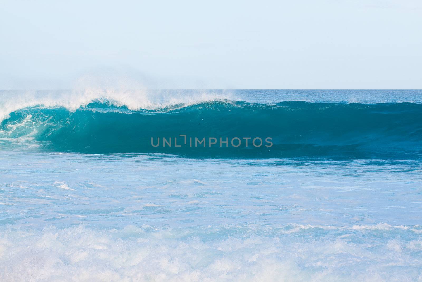 Large waves break off the north shore of oahu hawaii during a great time for surfers surfing.