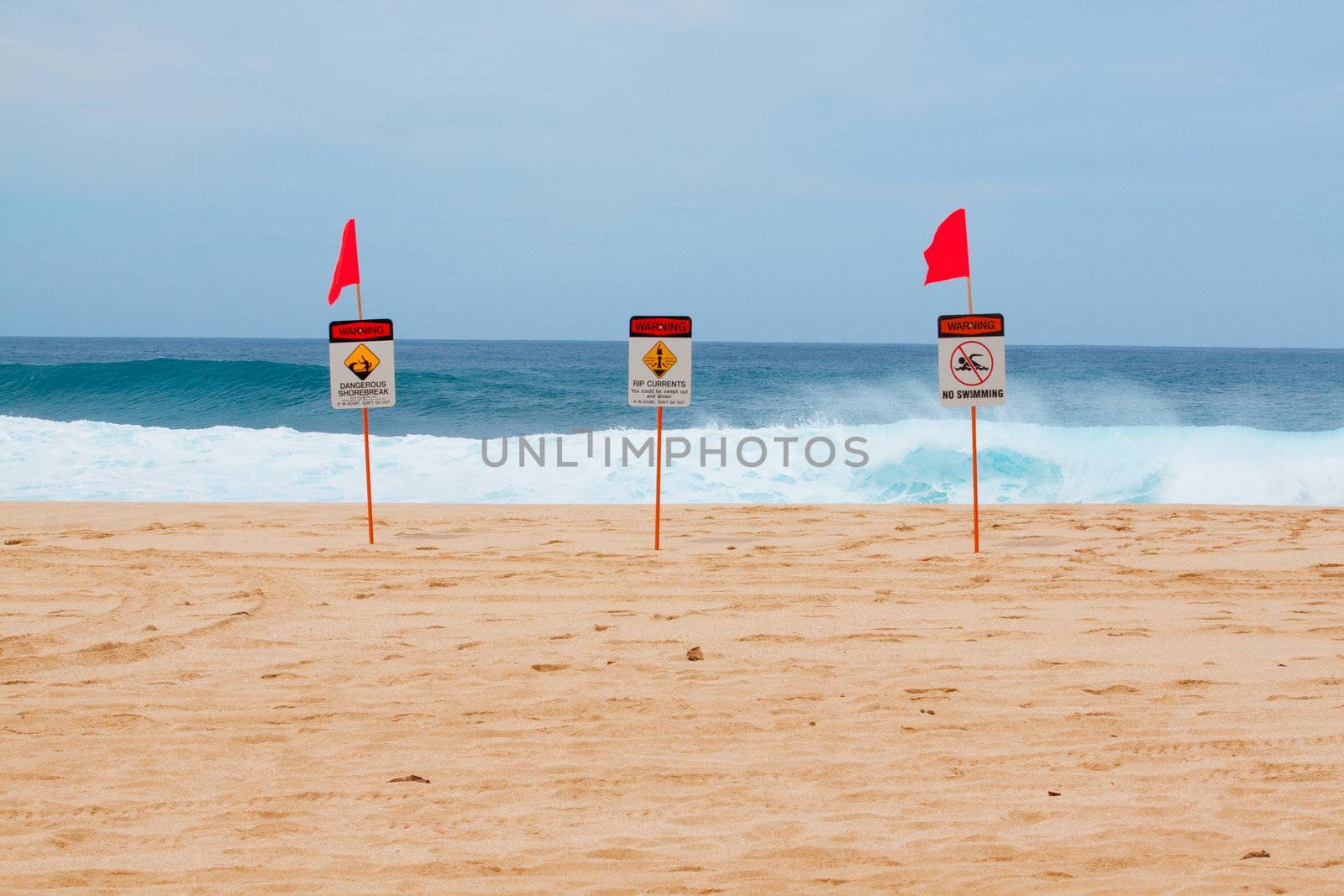 Warning signs mark where there is a very dangerous shore break and rip current along the north shore of Oahu Hawaii.