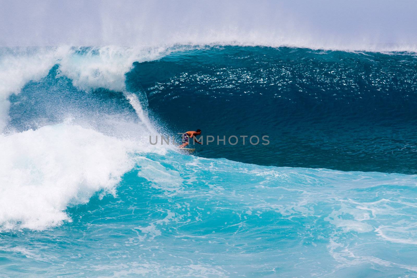 A surfer gets out in front of an enormous wave on the north shore of Hawaii Oahu.