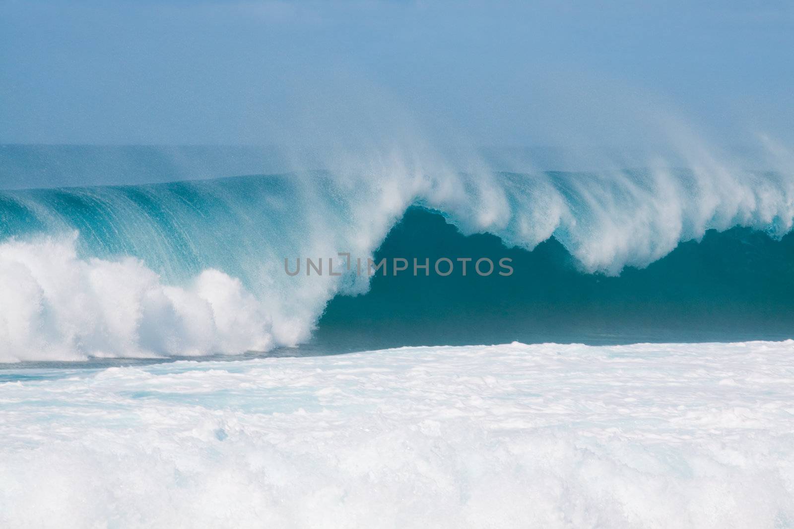 Large waves break off the north shore of oahu hawaii during a great time for surfers surfing.
