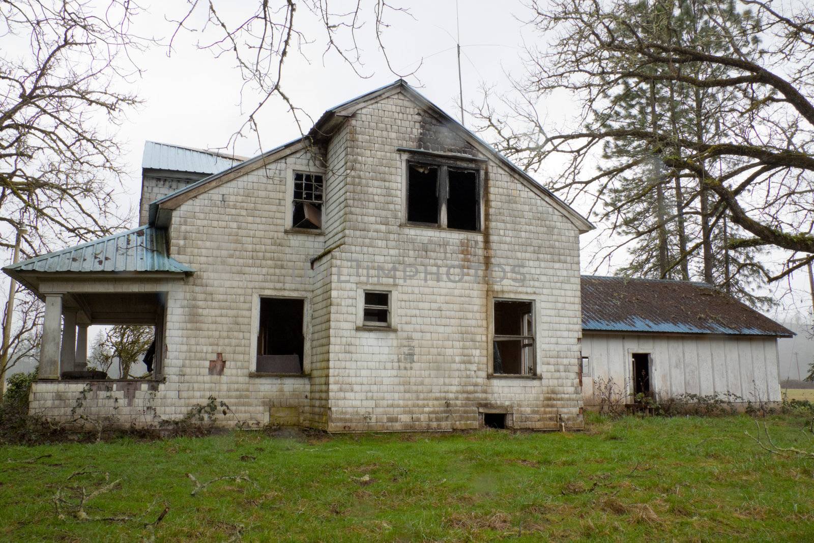 An old ranch home has been burned and abandoned.