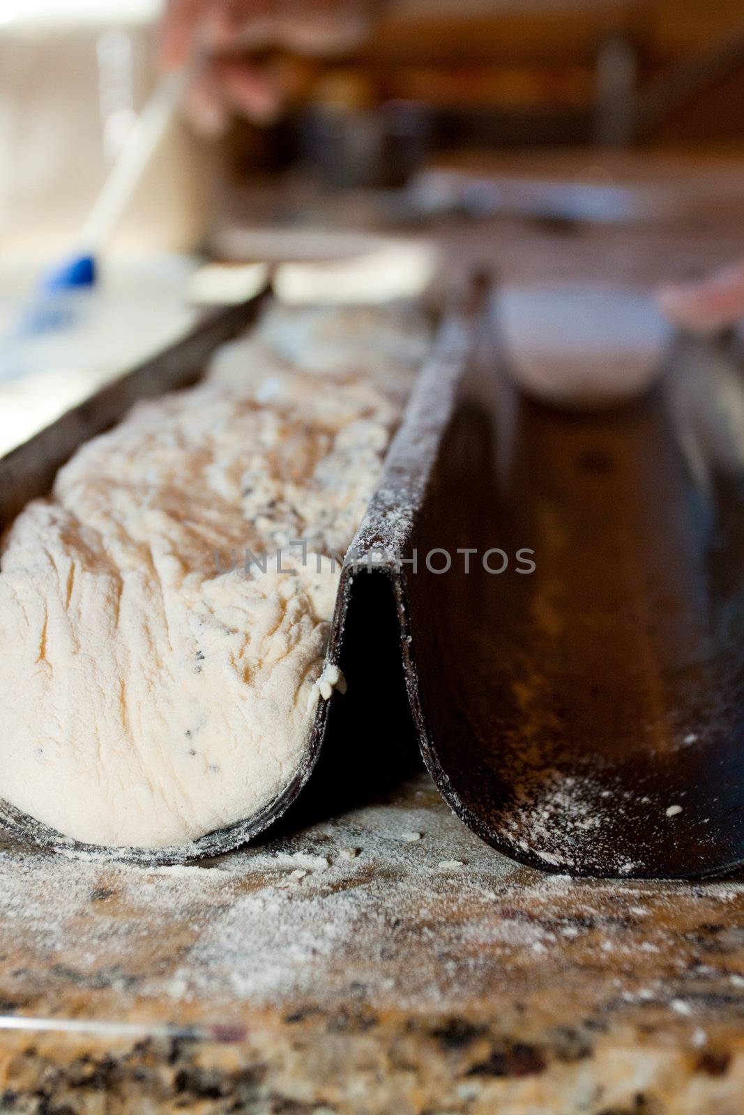 A baker prepares handmade artisan bread for baking.