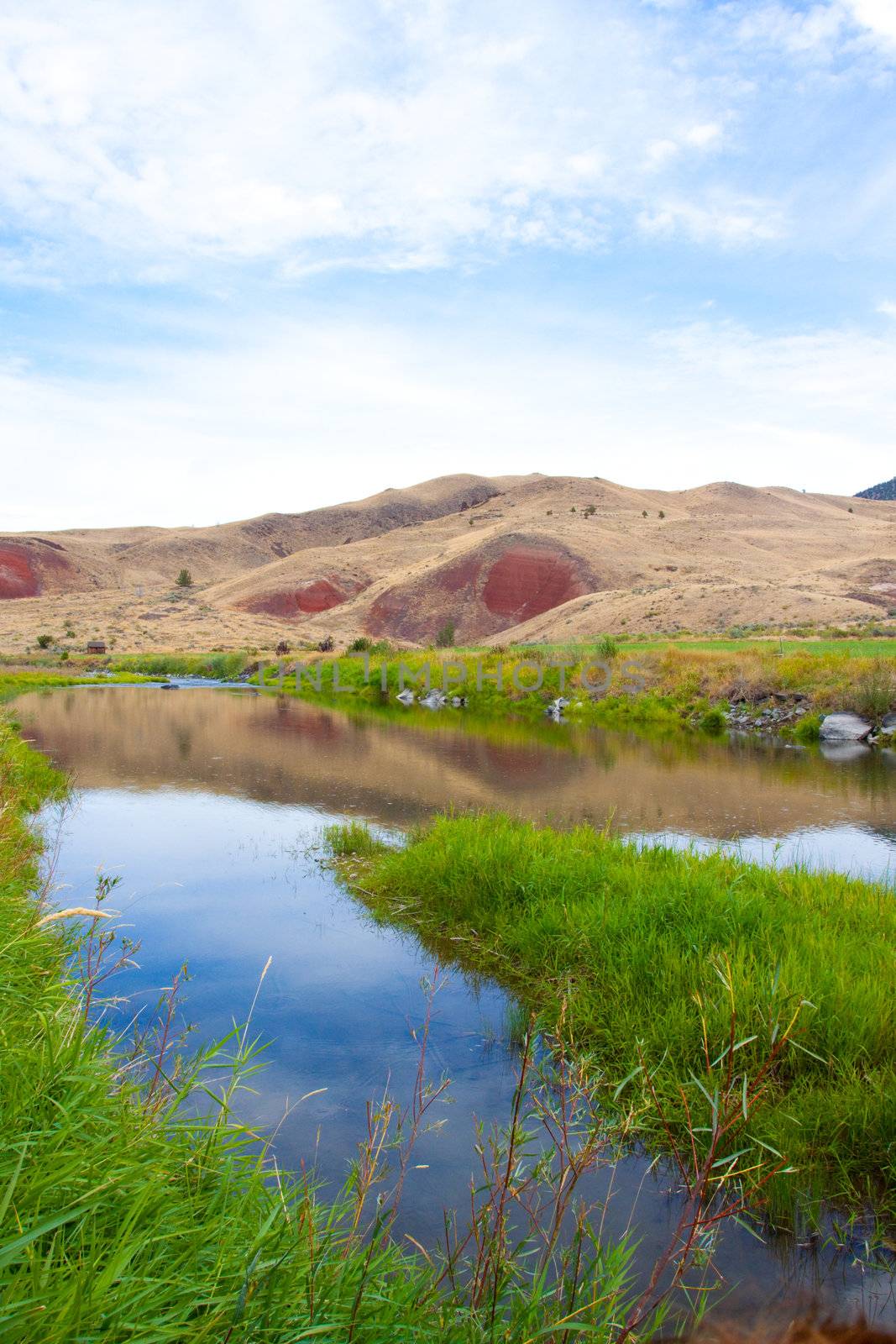 The John Day River flows slowly through the Painted Hills National Monument.