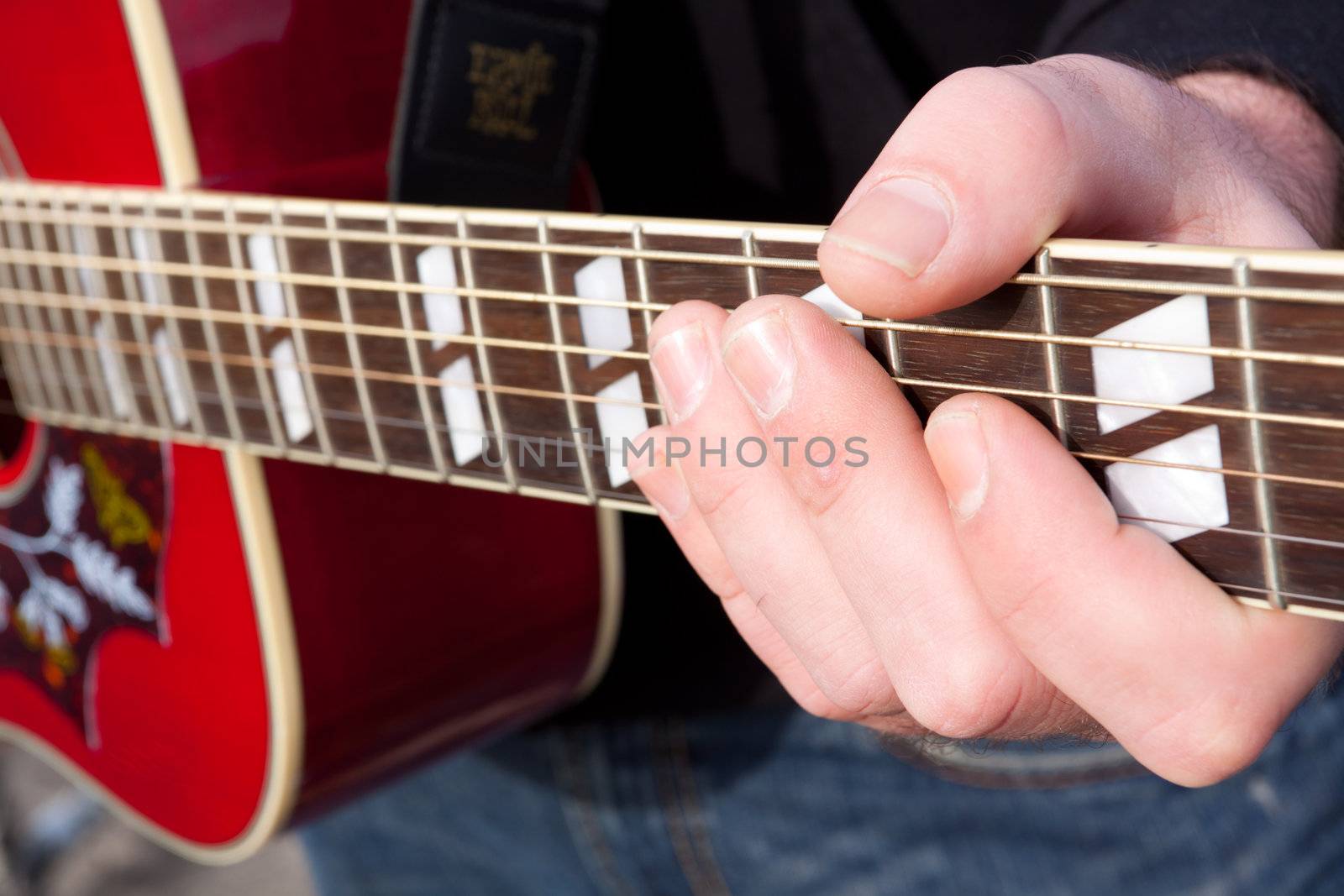 A guitar player's hand photographed for a closeup image of him forming a chord.