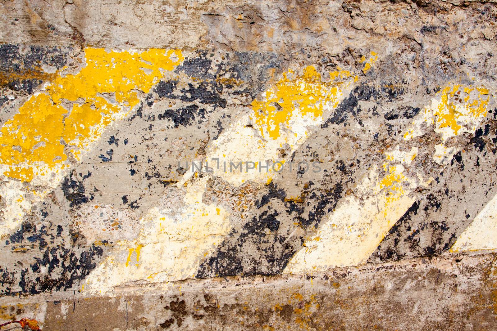 A black and yellow old wall is striped for warning or caution to create an abstract texture of a rubble decaying building wall.