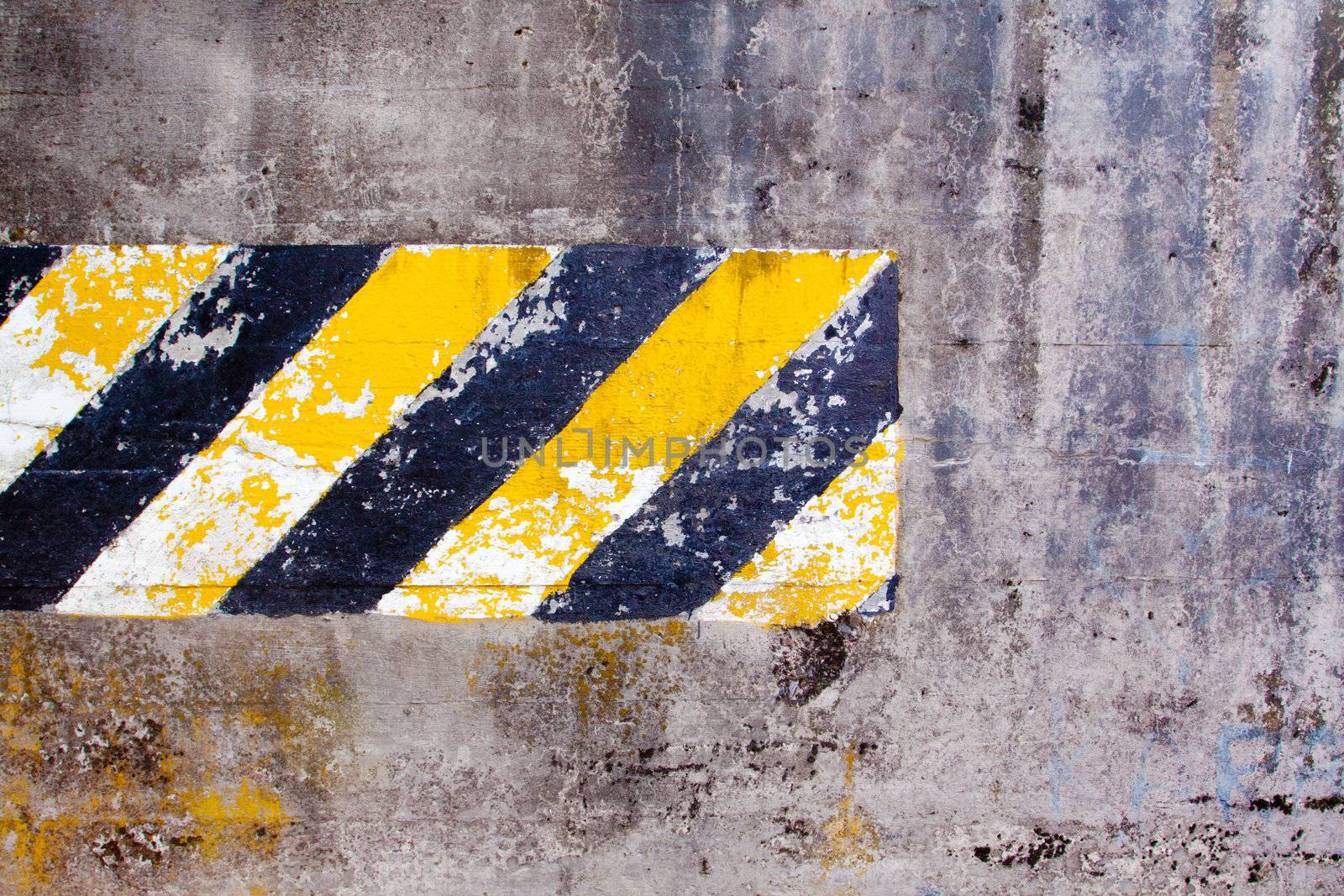 A black and yellow old wall is striped for warning or caution to create an abstract texture of a rubble decaying building wall.