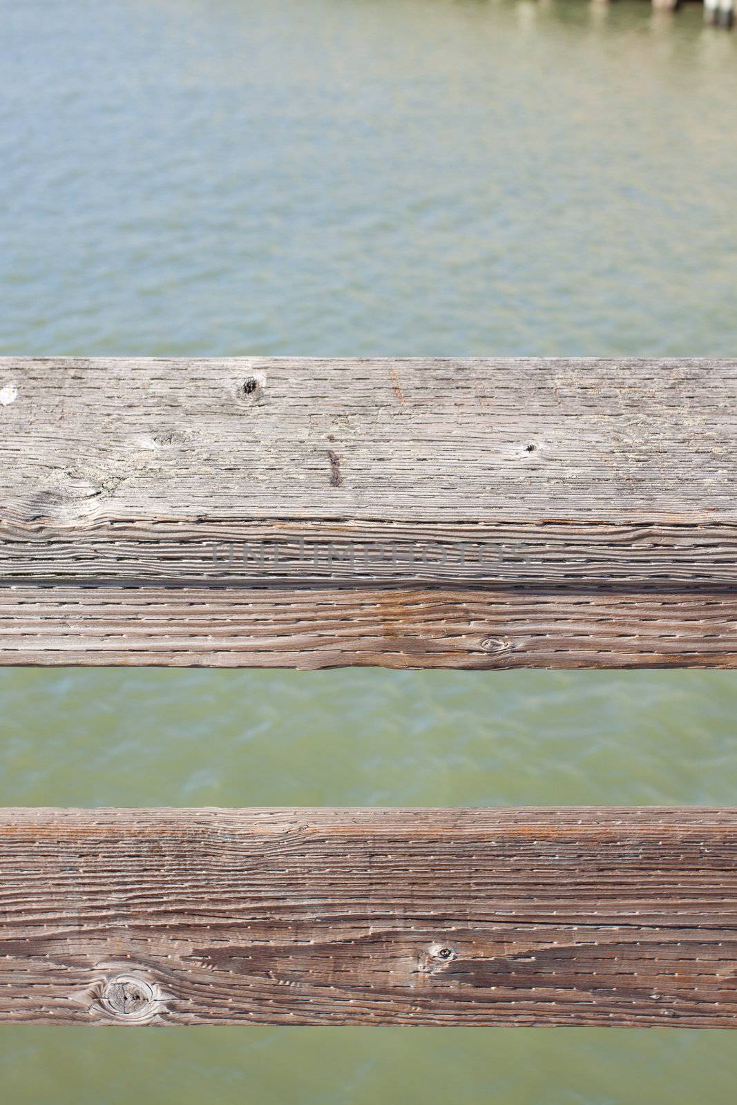 The railing of a pier is photographed in an abstract way to create some interesting texture images of wood and water.