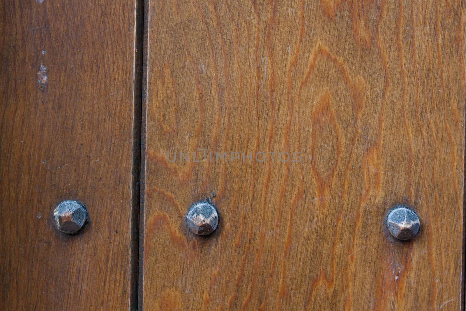 Metal pieces mounted to wood are photographed in a way to make an abstract texture background image from the materials.
