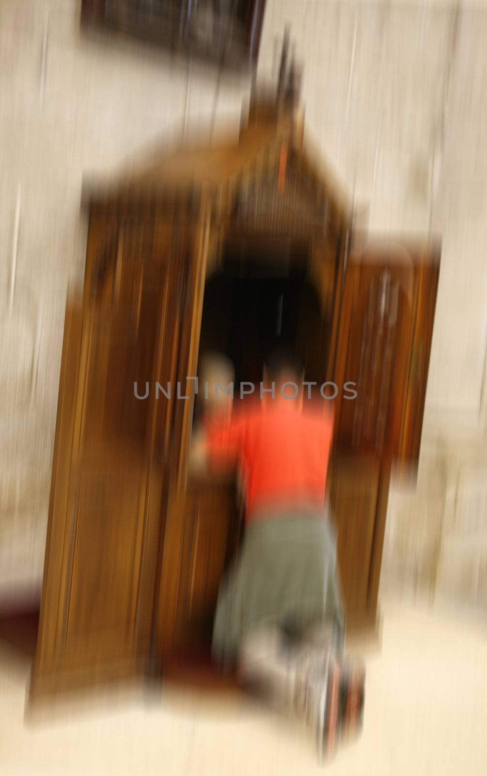 Pilgrim kneeling for confession in the Cathedral of Santiago de Compostela. Intentional motion blur to keep the privacy of the involved.