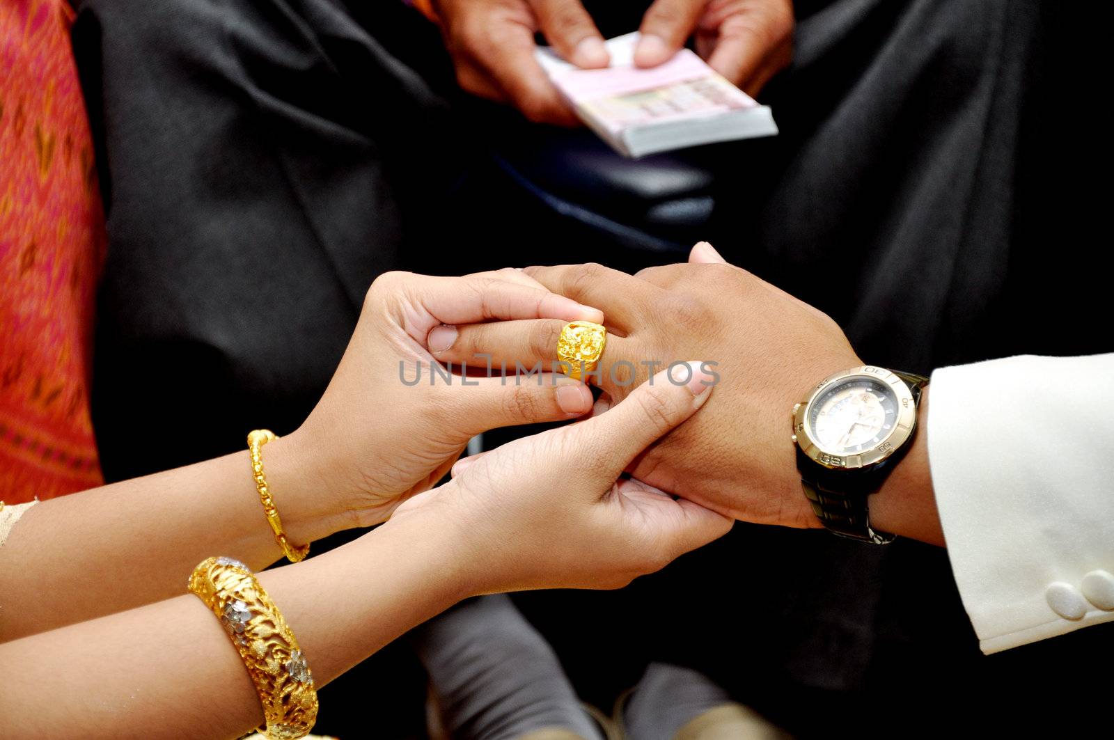 Bride wears wedding gold ring groom. only their hands in frame