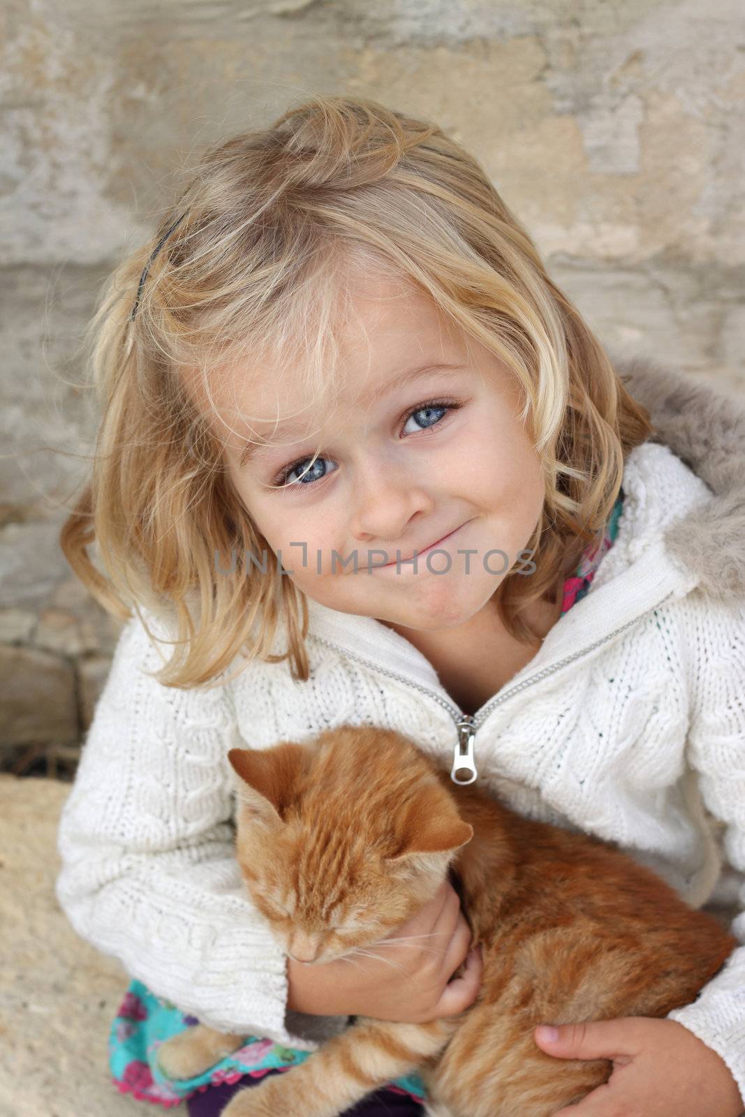 Cute litte girl holding a cat. Positive feeling