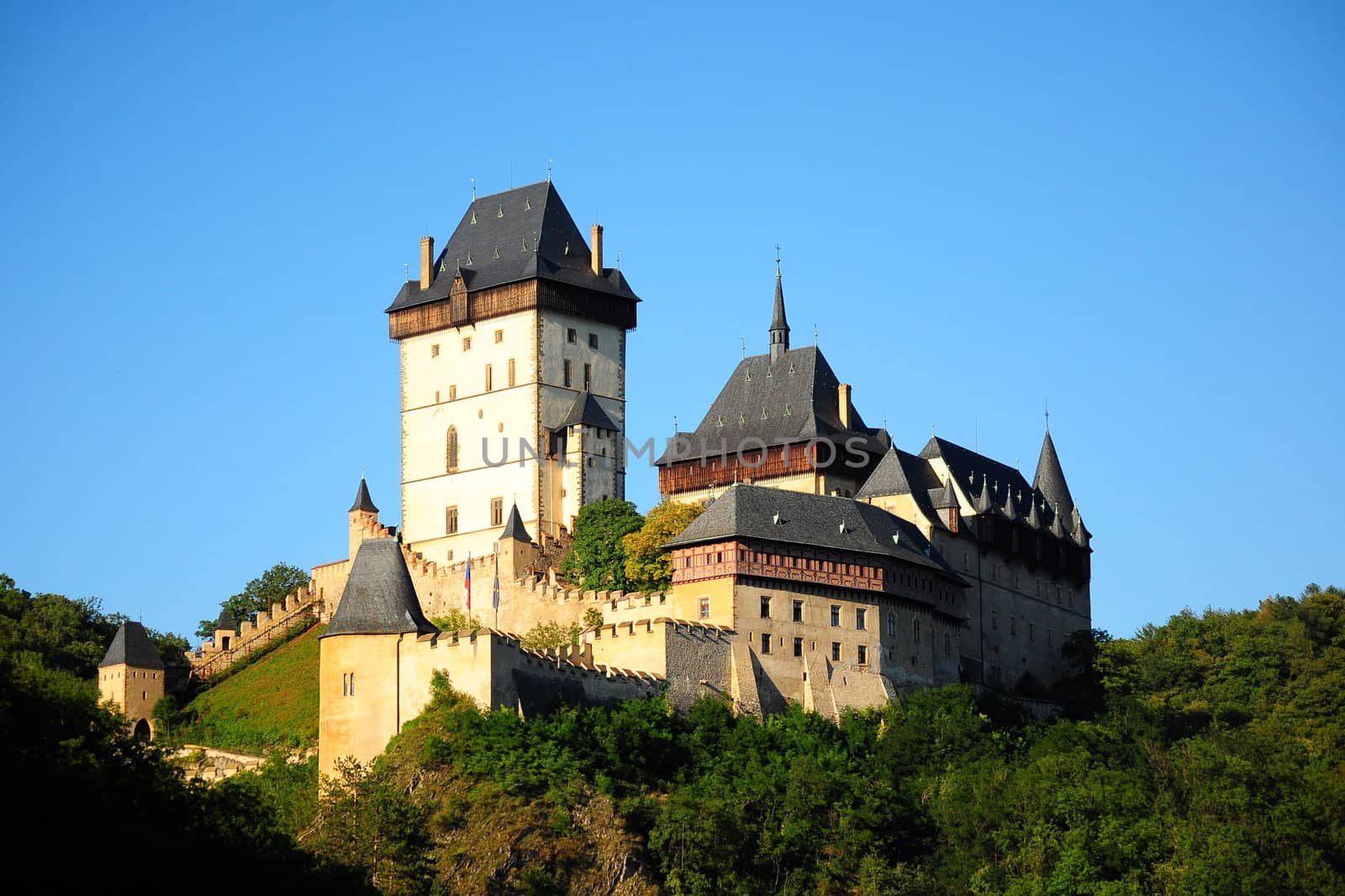 Panorama of the Karlstejn Castle over blue sky during the summer day