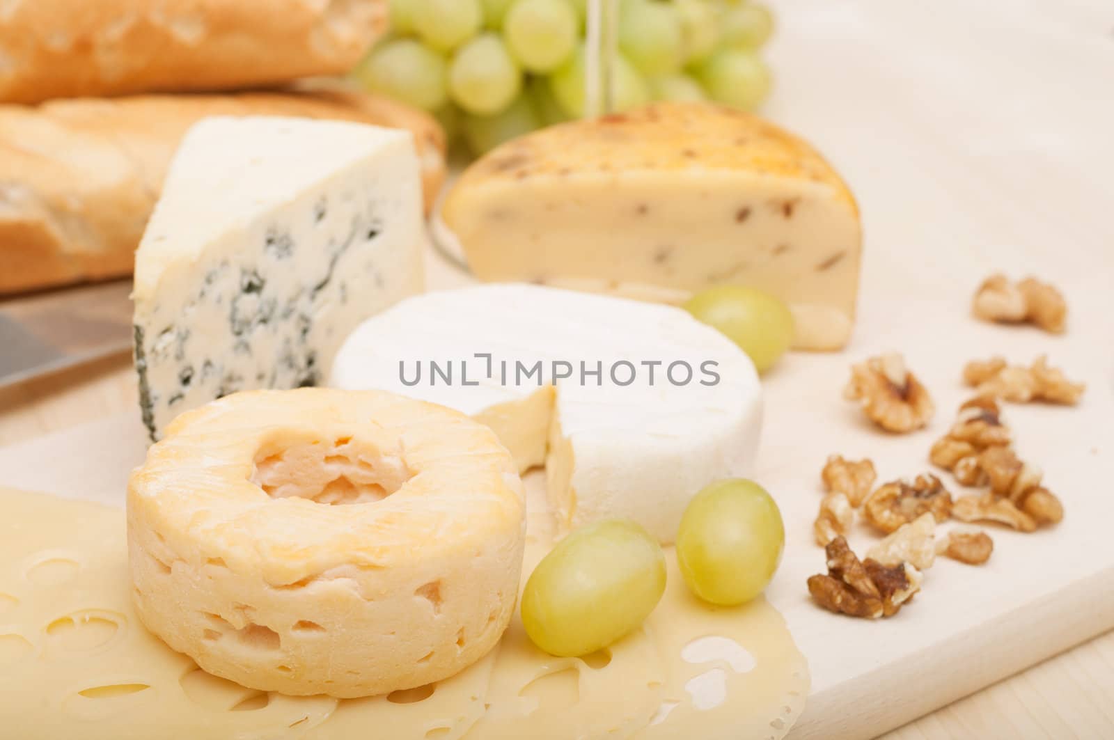Various Types of Cheese and Grapes on Wooden Chopping Board