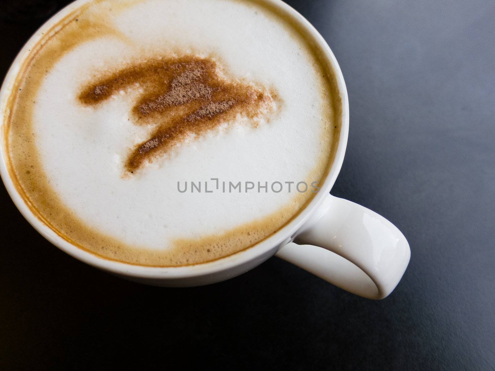 cappuccino coffee on black table by moggara12