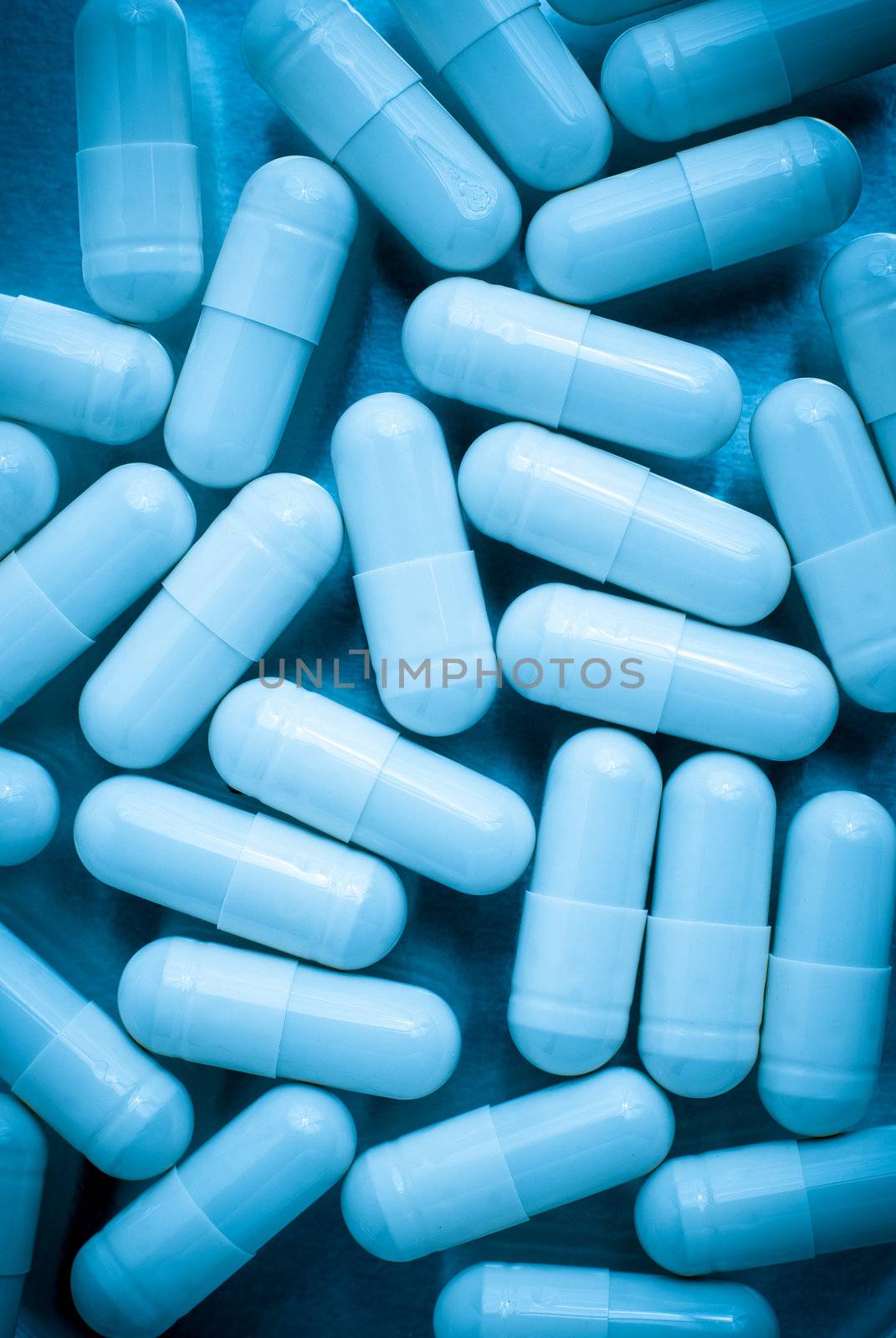 Macro view of pills on blue lit.